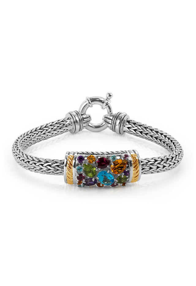 The 925 Sterling Silver & 18K Gold Multi Gemstone Bracelet, 3.25 TCW, features a woven design with a cylindrical centerpiece adorned with colorful gemstones and gold accents, finished with a round clasp.