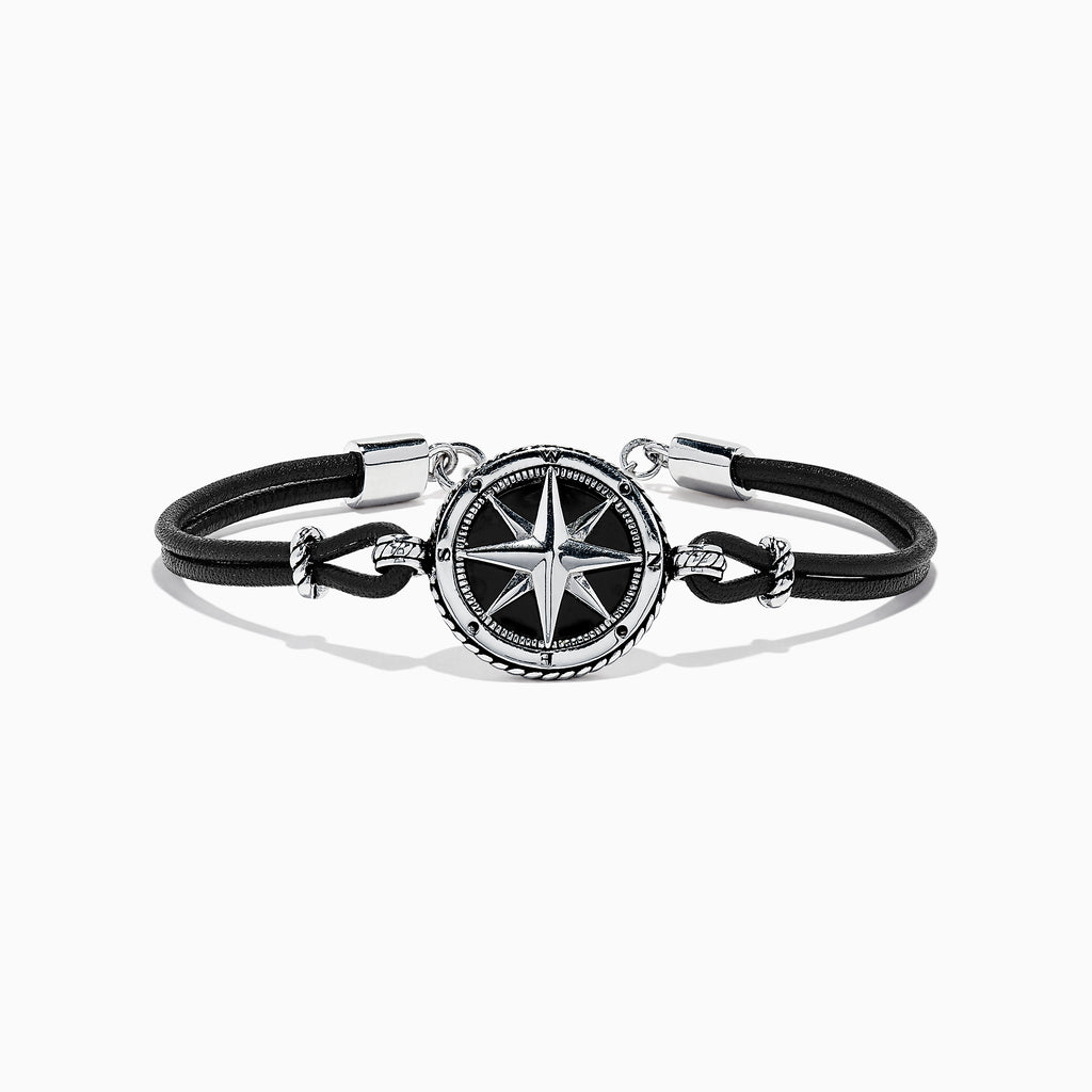 The Mens Sterling Silver Onyx Compass Leather Bracelet, 4.00 TCW, features a black cord with a round sterling silver compass rose charm, silver accents, and a clasp, shown on a white background.