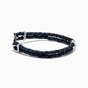 The Mens Sterling Silver Woven Leather Sapphire Anchor Bracelet, 0.52 TCW, features navy blue braided leather and a sterling silver anchor clasp set with sapphire gemstones.