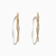 A pair of DOro 14K Yellow Gold 1 1/4 Diamond Wave Hoop Earrings, 0.25 TCW, with a twisted design and white diamonds along the front, displayed on a white background.