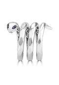 The 925 Sterling Silver Diamond and Sapphire Snake Ring, 0.12 TCW, features a coiled design with smooth surfaces and sparkling blue sapphire eyes, elegantly displayed on a white background.