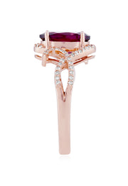 The Bordeaux 14K Rose Gold Rhodolite Garnet and Diamond Ring, 3.11 TCW, showcases a striking oval rhodolite garnet at its center with swirling diamond-accented bands—an exquisite choice for any occasion.