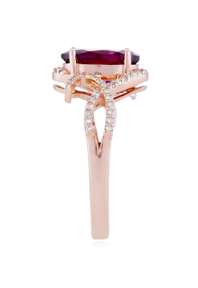 The Bordeaux 14K Rose Gold Rhodolite Garnet and Diamond Ring, 3.11 TCW, showcases a striking oval rhodolite garnet at its center with swirling diamond-accented bands—an exquisite choice for any occasion.