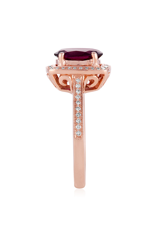 The Bordeaux 14K Rose Gold Rhodolite Garnet and Diamond Ring, 2.48 TCW showcases a large oval rhodolite garnet, double haloed by white diamonds, with additional diamond accents along the band.