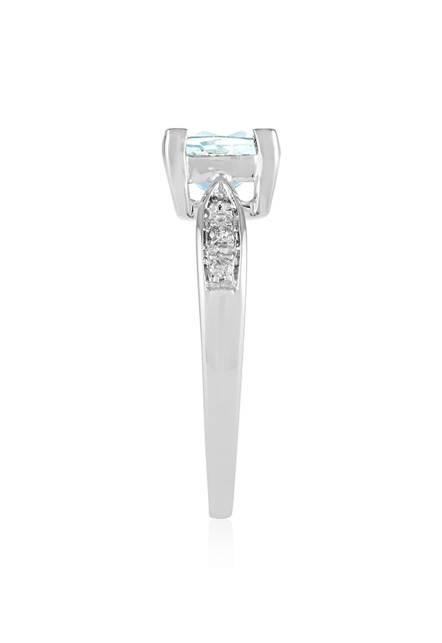 The Aquarius 14K White Gold Aquamarine and Diamond Ring, 1.35 TCW, showcases a prominent cushion-cut aquamarine centerpiece accented by sparkling round diamonds set into each side of the band.