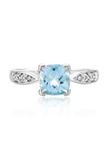 The Aquarius 14K White Gold Aquamarine and Diamond Ring, 1.35 TCW, showcases a prominent cushion-cut aquamarine centerpiece accented by sparkling round diamonds set into each side of the band.