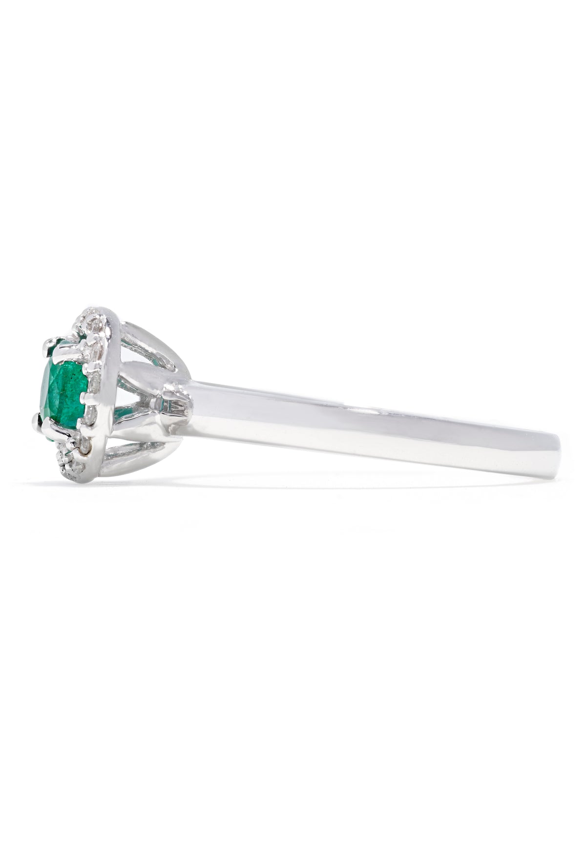The Brasilica 14K White Gold Emerald and Diamond Halo Ring, 0.60 TCW, features a round green emerald centered in a halo of sparkling white diamonds, presented against a white background.