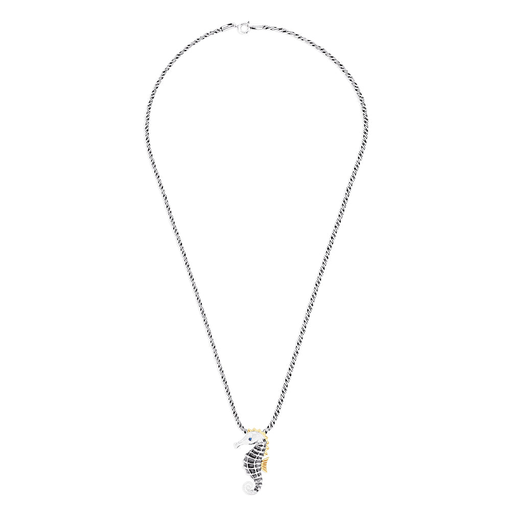 The Seaside Sterling Silver Sapphire and Diamond Seahorse Pendant features gold-accented fins and head, a sapphire gemstone eye, diamond details, and an elegant twisted chain design.