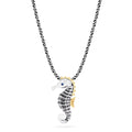 The Seaside Sterling Silver Sapphire and Diamond Seahorse Pendant features gold-accented fins and head, a sapphire gemstone eye, diamond details, and an elegant twisted chain design.