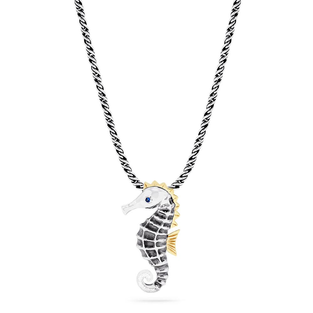 The Seaside Sterling Silver Sapphire and Diamond Seahorse Pendant features gold-accented fins and head, a sapphire gemstone eye, diamond details, and an elegant twisted chain design.