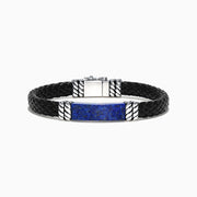 The Mens Sterling Silver Lapis Lazuli Leather Bracelet, 12.00 TCW, features a black braided leather band, a rectangular lapis lazuli centerpiece, sterling silver-toned accents, and a secure clasp.