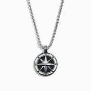 A Mens Sterling Silver Onyx Compass Pendant, 4.00 TCW, featuring a round design is shown on a silver chain and photographed on a white background.