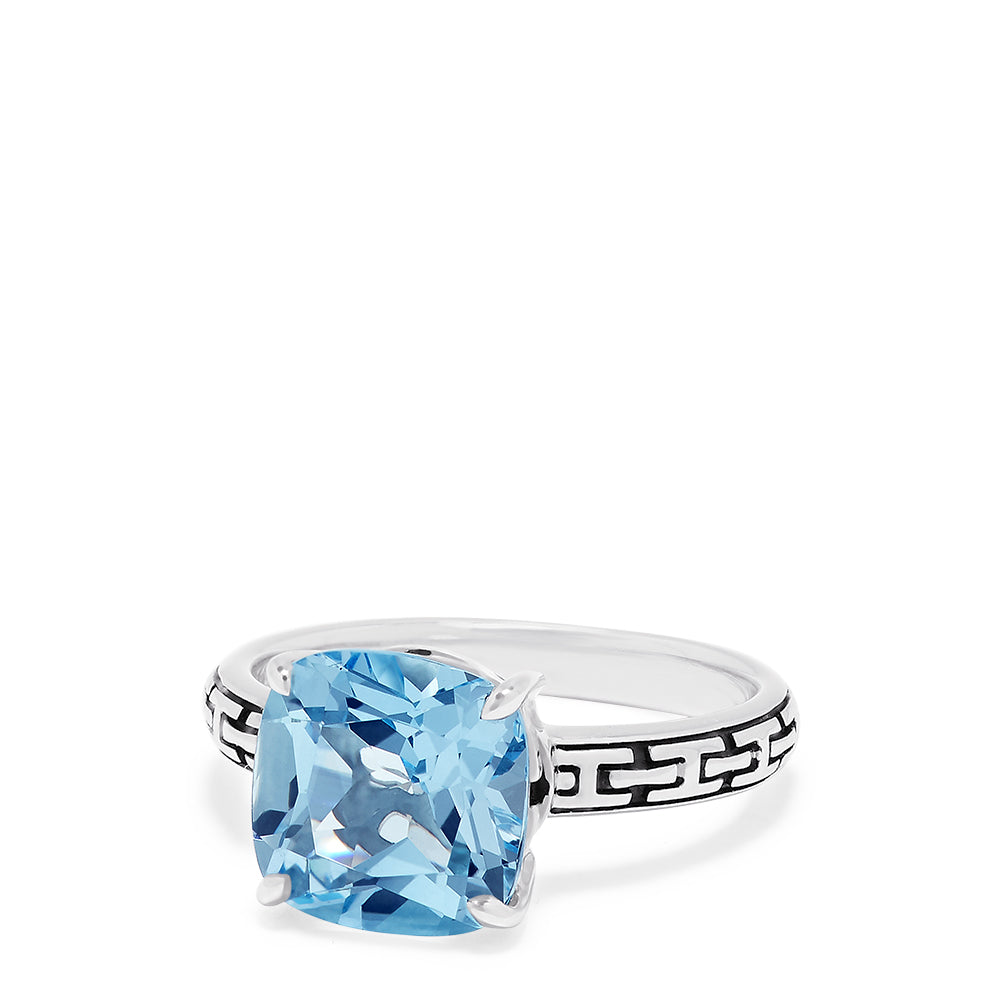 The 925 Sterling Silver Blue Topaz Ring, 5.20 TCW, features a square-cut light blue gemstone and geometric black engravings along the band, offering a modern and elegant style.