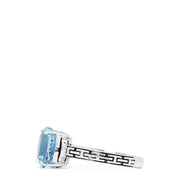 The 925 Sterling Silver Blue Topaz Ring, 5.20 TCW, features a square-cut light blue gemstone and geometric black engravings along the band, offering a modern and elegant style.