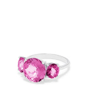 The 14K White Gold Pink Topaz Three Stone Ring, 8.00 TCW, showcases a brilliant round center pink topaz flanked by two smaller rounds, all set in luminous white gold for a stunning look.
