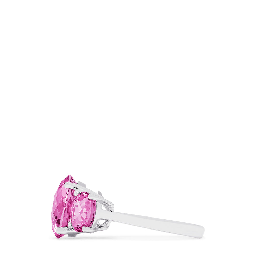 The 14K White Gold Pink Topaz Three Stone Ring, 8.00 TCW, showcases a brilliant round center pink topaz flanked by two smaller rounds, all set in luminous white gold for a stunning look.