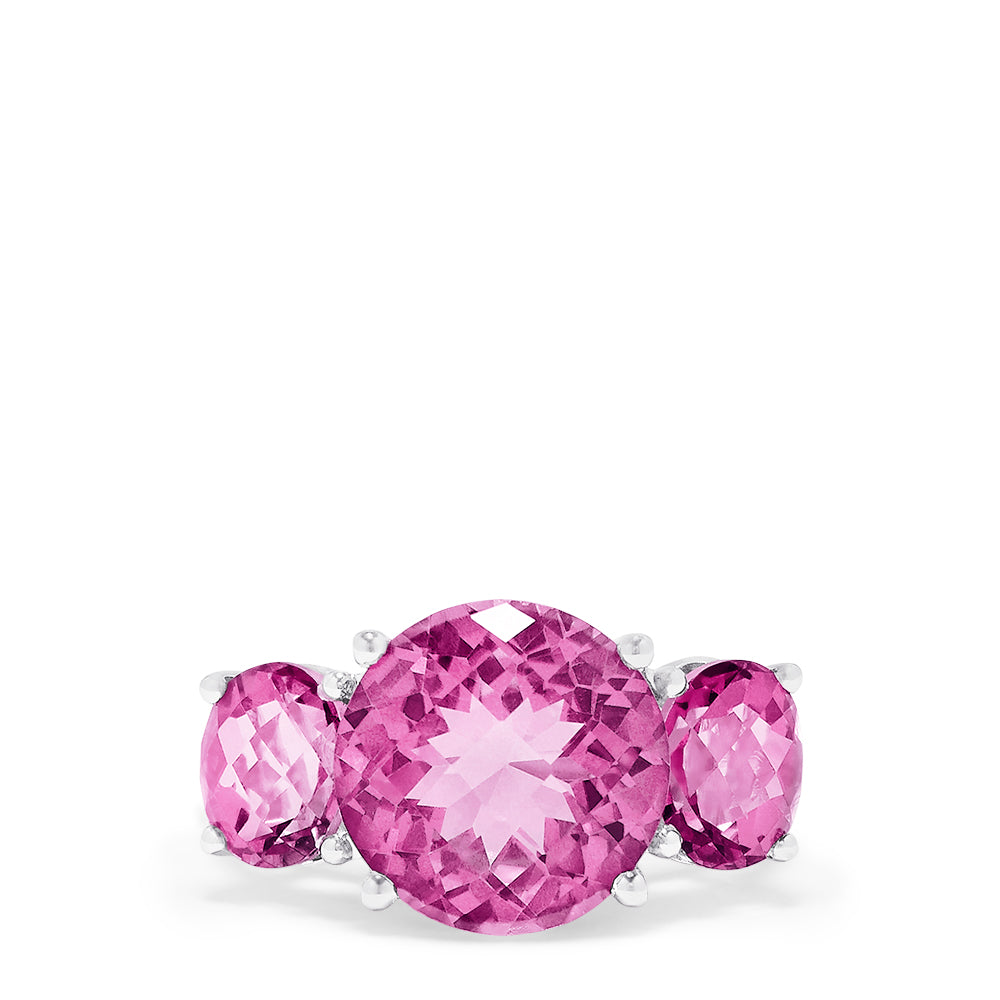 The 14K White Gold Pink Topaz Three Stone Ring, 8.00 TCW, showcases a brilliant round center pink topaz flanked by two smaller rounds, all set in luminous white gold for a stunning look.