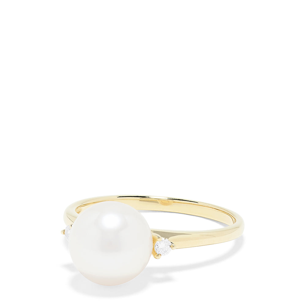 The 14K Yellow Gold Cultured Pearl and Diamond Accented Ring, 0.05 TCW, features a large round cultured pearl at the center with diamond accents on each side, shown on a plain white background.