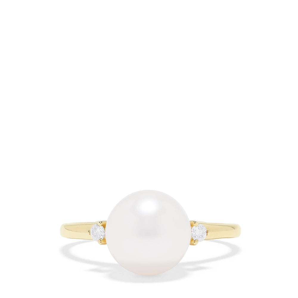 The 14K Yellow Gold Cultured Pearl and Diamond Accented Ring, 0.05 TCW, features a large round cultured pearl at the center with diamond accents on each side, shown on a plain white background.