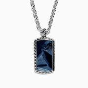 The Mens Sterling Silver Pietersite Dog Tag Pendant, 9.50 TCW, features a rectangular dog tag with a dark blue marbled pietersite stone set in an ornate silver frame on a sterling silver chain.