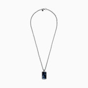 The Mens Sterling Silver Pietersite Dog Tag Pendant, 9.50 TCW, features a rectangular dog tag with a dark blue marbled pietersite stone set in an ornate silver frame on a sterling silver chain.