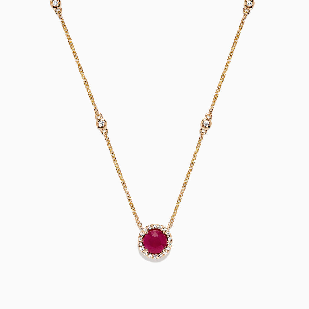 The Ruby Royale 14K Yellow Gold Ruby and Diamond Station Necklace, 1.11 TCW, features a round ruby pendant surrounded by diamonds and additional diamond accents spaced along the chain.