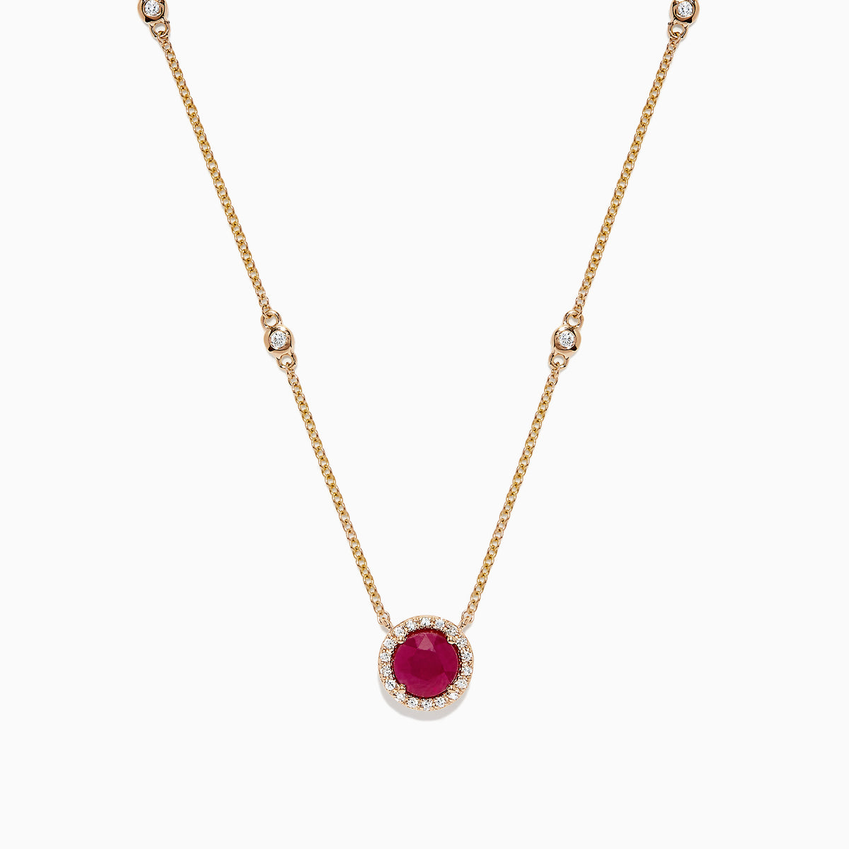 The Ruby Royale 14K Yellow Gold Ruby and Diamond Station Necklace, 1.11 TCW, features a round ruby pendant surrounded by diamonds and additional diamond accents spaced along the chain.