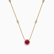 The Ruby Royale 14K Yellow Gold Ruby and Diamond Station Necklace, 1.11 TCW, features a round ruby pendant surrounded by diamonds and additional diamond accents spaced along the chain.