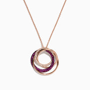 The Ruby Royale 14K Rose Gold Pendant showcases three interlocking ruby and diamond circles (0.66 TCW) on a delicate chain, set against a white background.