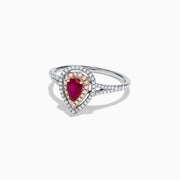 The Ruby Royale 14K Two Tone Gold Ring features a pear-shaped ruby at the center, surrounded by two halos of sparkling diamonds (0.77 TCW), elegantly set and displayed on a plain white background.
