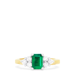 The Brasilica 14K 2-Tone Gold Emerald and Diamond Ring (1.36 TCW) features a rectangular green emerald center, accented by three round white diamonds on each side in a symmetrical design.
