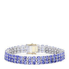 The Sterling Silver with 14K Yellow Gold Lock Tanzanite Bracelet, 20.00 TCW, features three rows of alternating blue and clear gemstones and a rectangular silver and 14K yellow gold clasp at the center.