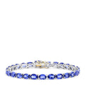 The Sterling Silver with 14K Gold Lock Tanzanite Tennis Bracelet, 20.00 TCW, features a row of sparkling tanzanites and a gold-accented clasp, beautifully displayed against a white background.