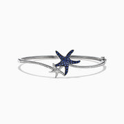The Seaside 14K Gold Blue Sapphire & Diamond Starfish Bracelet, 1.06 TCW features two starfish—one adorned with blue sapphires, the other with diamond accents—plus sparkling clear stones along part of the bangle.