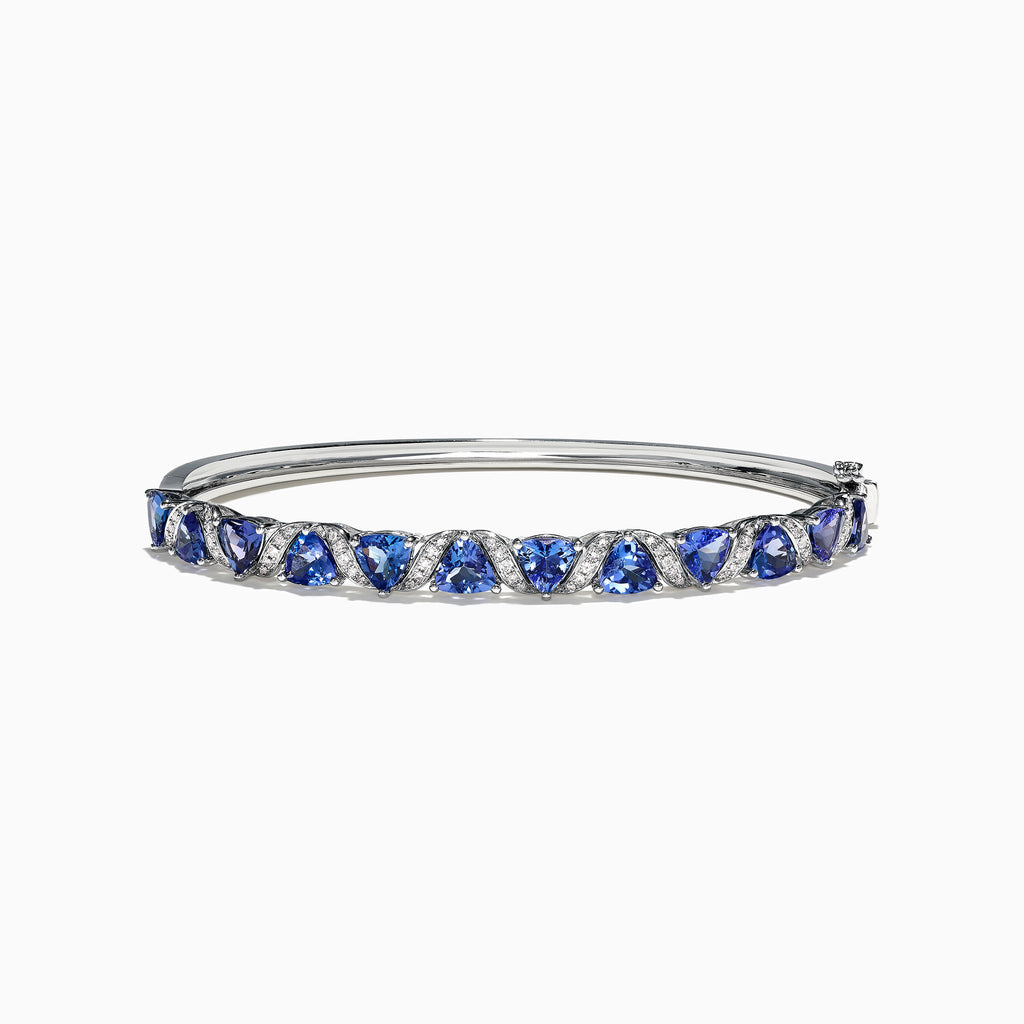 The Nahla Siri 14K White Gold Tanzanite Diamond Bangle, 4.76 TCW, features a row of blue triangle-cut tanzanite gems set between small diamonds along the top half of the band.