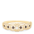 The 14K Yellow Gold Diamond Filigree Bangle, 2.03 TCW, features intricate filigree patterns and sparkling diamond clusters, elegantly detailed along the band.