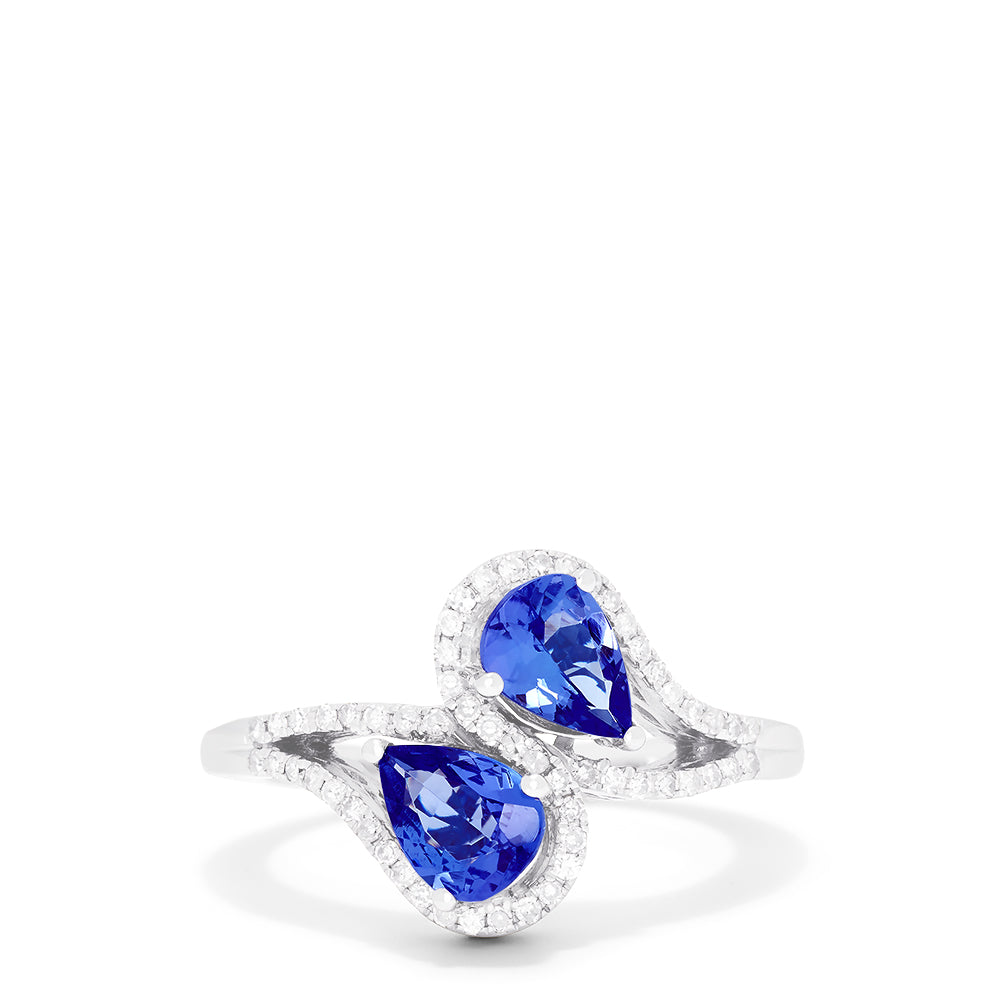 The 14K White Gold Pear Shaped Tanzanite and Diamond Bypass Ring, 0.74 TCW, features two pear-shaped blue tanzanites each with a diamond halo, set side by side in an elegant bypass design.