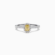 The Canare 18K Two-Tone Gold Yellow and White Diamond Ring, 0.79 TCW, showcases an oval yellow gemstone surrounded by a halo of clear diamonds and more diamonds on the band, beautifully displayed on a white background.