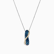 This 14K two tone gold necklace features a crossover pendant with blue and white diamonds (1.00 TCW) on one side, clear gemstones on the other, separated by a gold-toned wavy line.