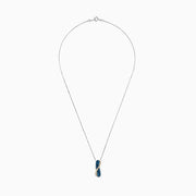 This 14K two tone gold necklace features a crossover pendant with blue and white diamonds (1.00 TCW) on one side, clear gemstones on the other, separated by a gold-toned wavy line.