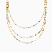 The 14K Yellow Gold 18 Layered Paperclip Chain Necklace features three delicate chains with elongated rectangular links, elegantly displayed on a white background for a timeless, sophisticated look.