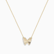 The 14K Yellow Gold Ribbed Butterfly Necklace features a delicate gold chain with a textured butterfly pendant, elegantly showcased against a plain white background.