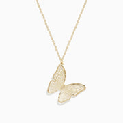 The 14K Yellow Gold Slanted Butterfly Pendant features a delicate gold chain and is displayed against a white background.