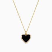 The 14K Yellow Gold Onyx and Diamond Heart Pendant features a heart-shaped onyx accented with sparkling diamonds, all set on a classic yellow gold chain for an elegant touch.