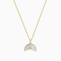 A 14K yellow gold necklace with a delicate chain, featuring the Seaside Whale Tail Pendant accented with mother of pearl and sparkling diamonds.