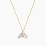 A 14K yellow gold necklace with a delicate chain, featuring the Seaside Whale Tail Pendant accented with mother of pearl and sparkling diamonds.