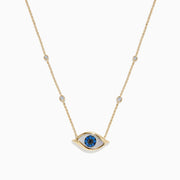 The Novelty 14K Yellow Gold Sapphire and Diamond Evil Eye Necklace features an eye-shaped pendant with a sapphire center, blue stones, and four diamond accents set along a delicate gold chain.