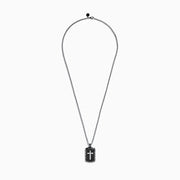 The Mens Sterling Silver Black Sapphire Cross Dog Tag Pendant, 1.87 TCW, features a rectangular design with a silver cross centerpiece, black accents, and an elegant border on a classic chain necklace.