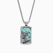 The Men’s Sterling Silver Turquoise Wave Pendant, 10.50 TCW, features a rectangular design with an engraved ocean wave and a vibrant turquoise stone background.