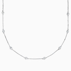 The 14K White Gold 18 Diamond Station Necklace showcases evenly spaced round bezel-set diamonds totaling 1.00 TCW, elegantly displayed against a white background.